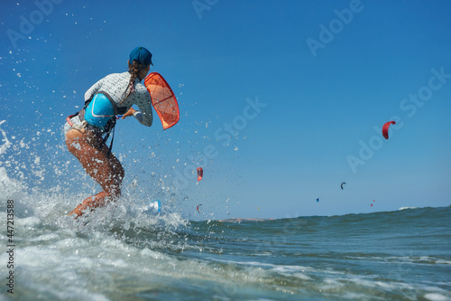 Kite surfer woman jumps with kiteboard  in transition and throws up the board