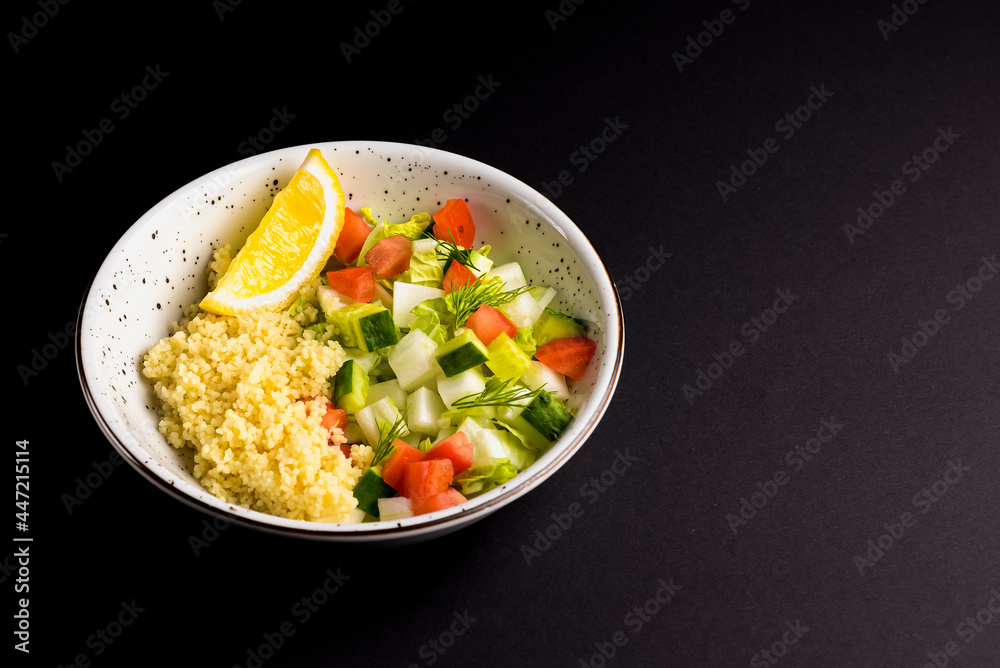 Bulgur with vegetables in a plate over black background. Delicious healthy dish in a bowl Bulgur with vegetables in a plate over black background. Delicious healthy dish in a bowl