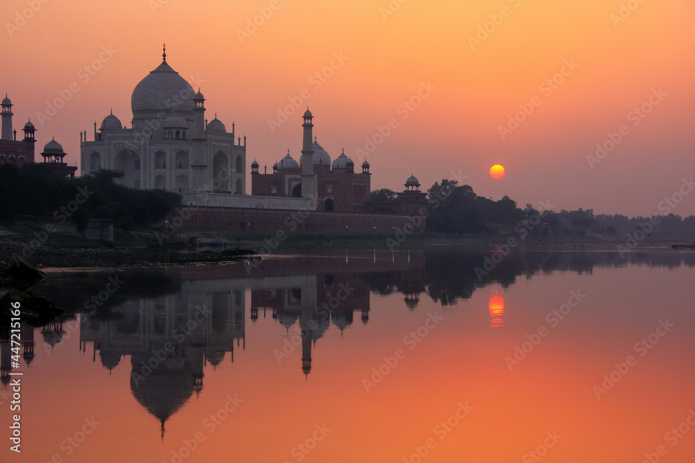 Obraz premium Taj Mahal reflected in Yamuna river at sunset in Agra, India