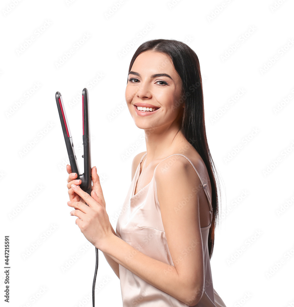 Fototapeta premium Beautiful young woman with flattening iron on white background
