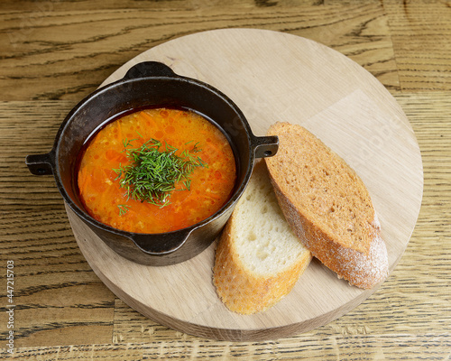 Traditional Russian soup rassolnik with barley, potato and kelp, served in a bowl with 2 pieces of bread