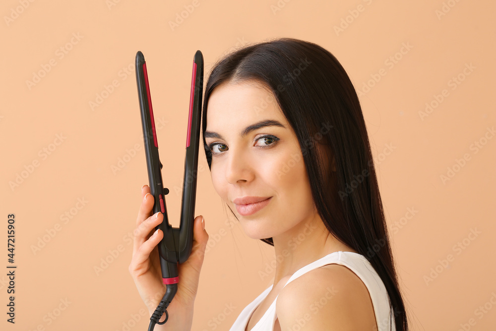 Beautiful young woman with flattening iron on color background Beautiful young woman with flattening iron on color background