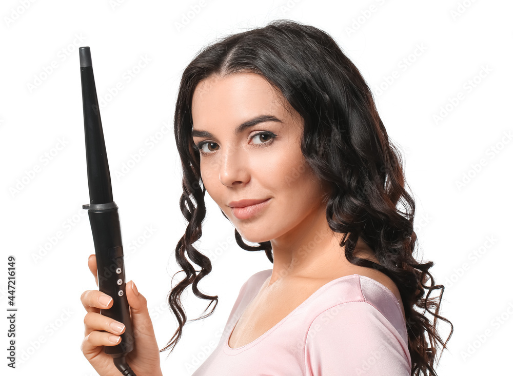 Beautiful young woman with curling iron on white background Beautiful young woman with curling iron on white background