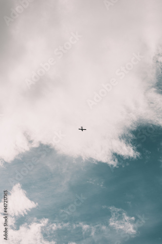 Ein kleines Flugzeug fliegt im Himmel bei weißen Wolken