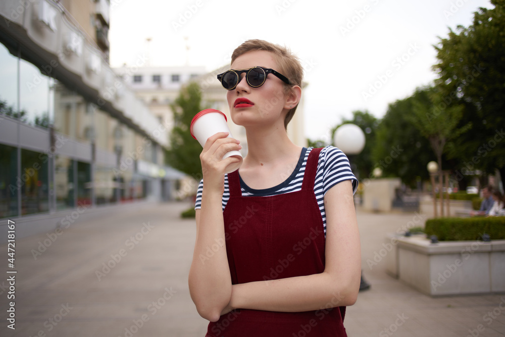 pretty woman with glasses outdoors walking coffee in hands