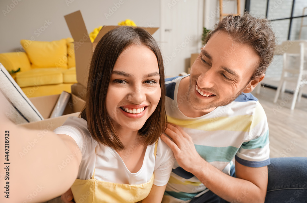 Young couple taking selfie in room on moving day Young couple taking selfie in room on moving day