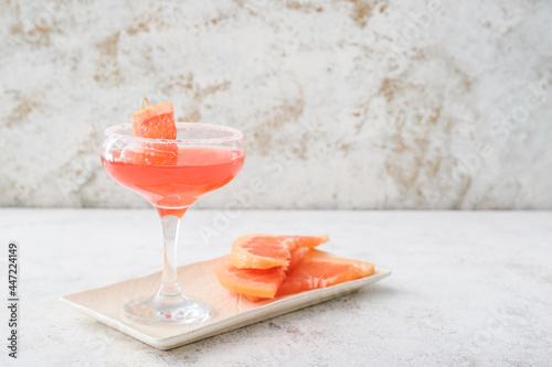 Glass of Hemingway daiquiri cocktail and grapefruit on grunge background photo