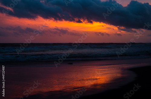Beautiful sunset at Paradise island Sri Lanka, Bright vivid orange skyline, and the reflection on the beach waves creating perfect balance and harmony.