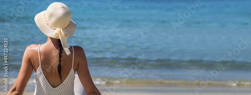 woman in hat on the beach sunbathing with space for copy