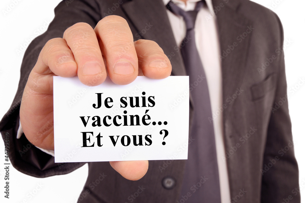 Homme tenant une carte sur laquelle est écrit en français je suis vacciné et vous ? Homme tenant une carte sur laquelle est écrit en français je suis vacciné et vous ?