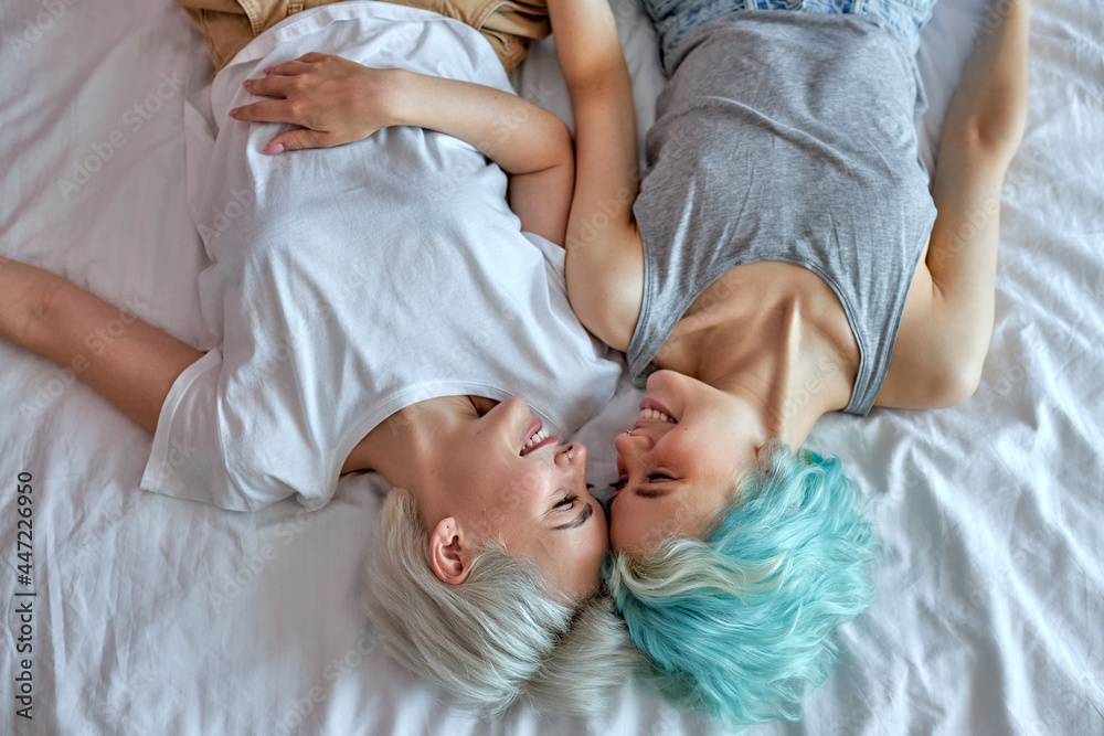 Top view Lesbian couple kissing and hugging on bed, give each other passionate kiss. Candid situation with real people. Homosexuality and lifestyle concepts. View from above, copy space Top view Lesbian couple kissing and hugging on bed, give each other passionate kiss. Candid situation with real people. Homosexuality and lifestyle concepts. View from above, copy space