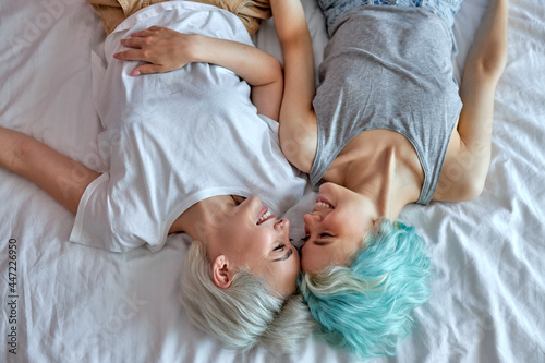 Top view Lesbian couple kissing and hugging on bed, give each other passionate kiss. Candid situation with real people. Homosexuality and lifestyle concepts. View from above, copy space