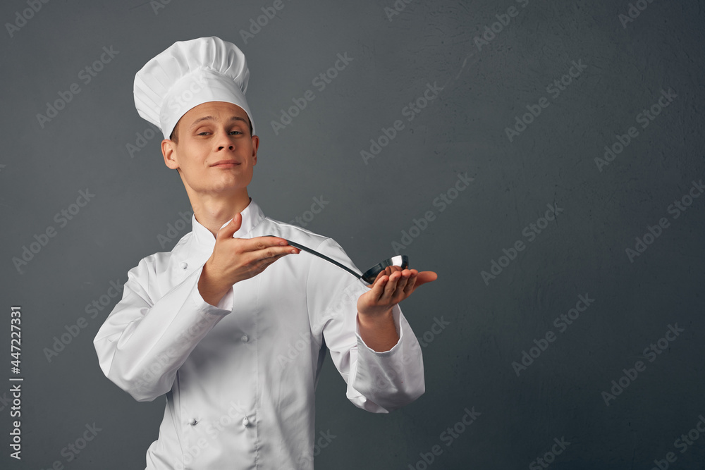Cheerful chef with a ladle in his hands, professional cooking Cheerful chef with a ladle in his hands, professional cooking