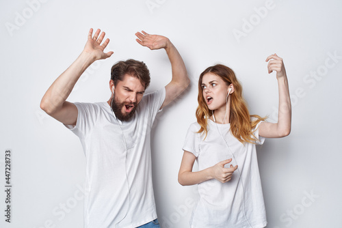 woman and man in white t-shirts are standing next to fun family studio
