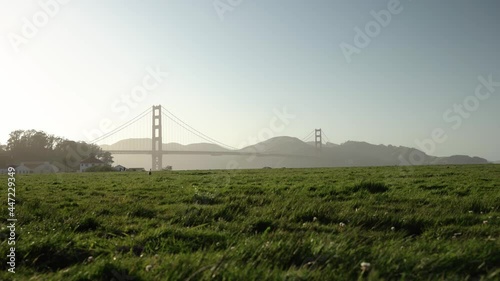 Scenic landscape view of a grass field and the Golden Gate Bridge in the background photo