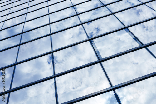 Glass skyscraper building with cloudy blue sky background