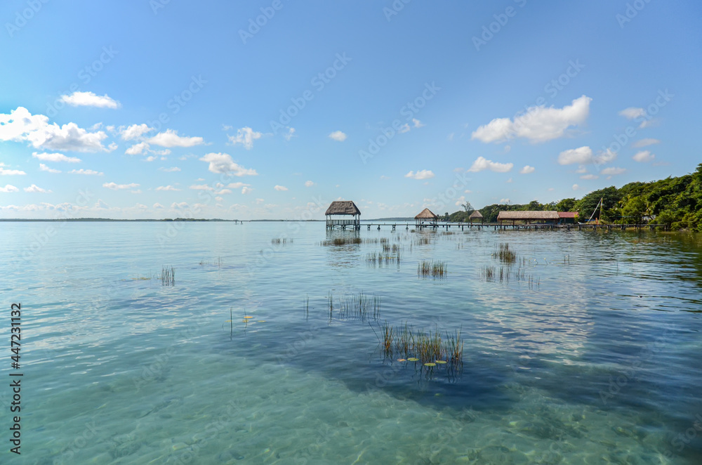 Bacalar Lagoon at Mexico Caribbean. Cabins for swimming in the turquoise freshwater of the lake. Touristic and tropical travel destination. Tropical vacation background with copy space.