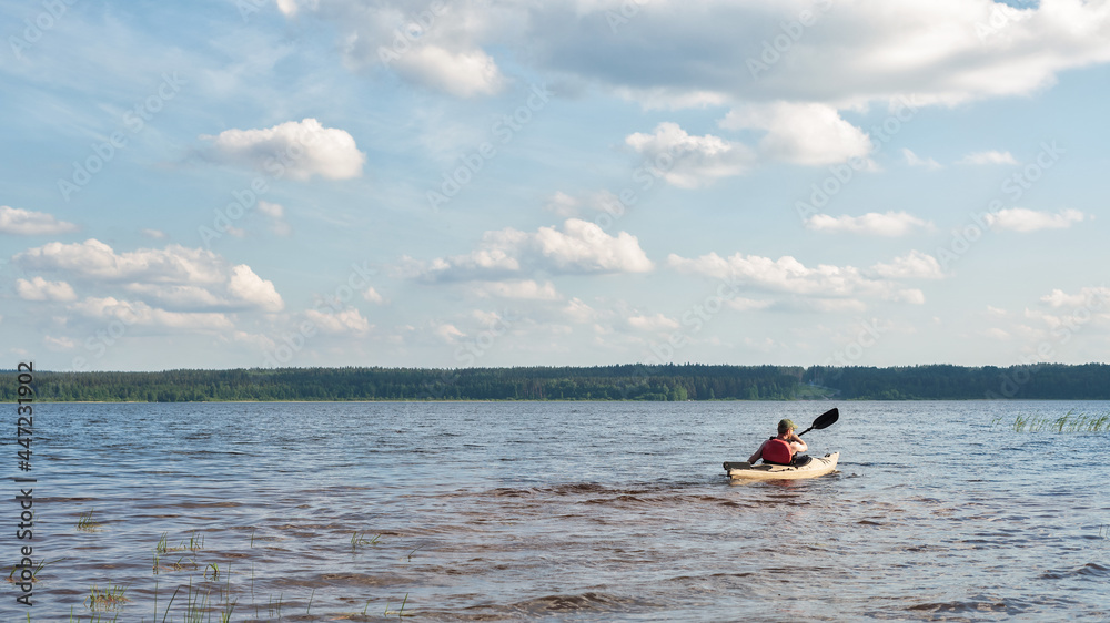 a man is kayaking on a river on a bright sunny day.