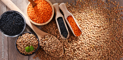 Composition with three sorts of lentils on wooden table