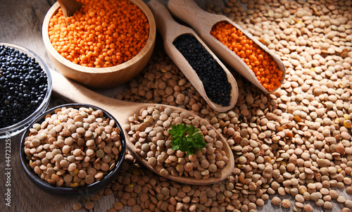 Composition with three sorts of lentils on wooden table