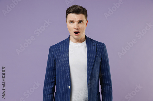 Shocked sad young successful employee business man corporate lawyer 20s wears formal blue suit white t-shirt work in office look aside open mouth isolated on pastel purple background studio portrait.