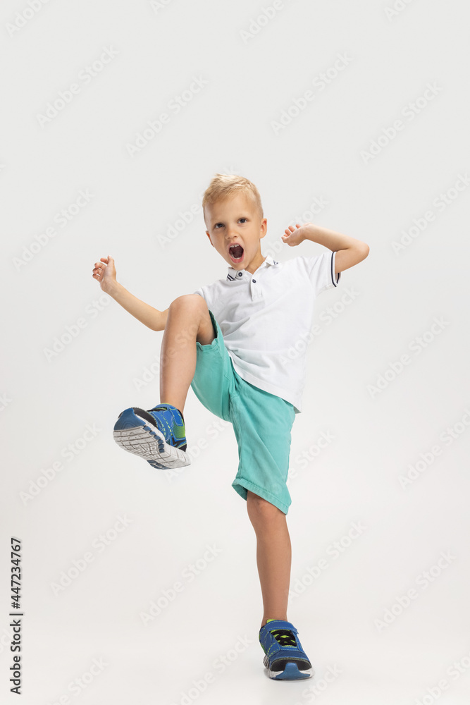 Portrait of cute preschool boy in shirt and shorts isolated on white studio background. Copyspace for ad. Childhood, education, emotion concept Portrait of cute preschool boy in shirt and shorts isolated on white studio background. Copyspace for ad. Childhood, education, emotion concept