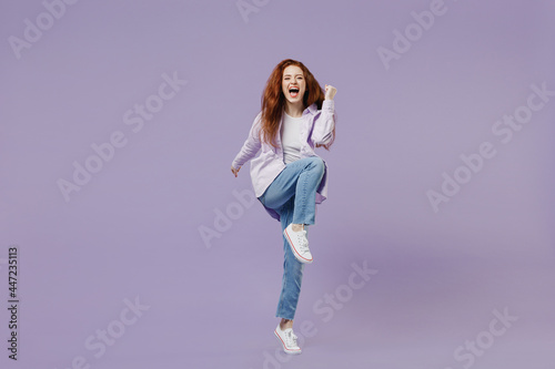 Full size body length energy active young redhead curly green-eyed woman 20s wears white T-shirt violet jacket doing aerobics training isolated on pastel purple color wall background studio portrait.