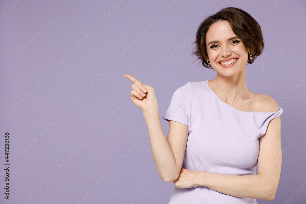 Young smiling happy woman 20s with bob haircut wearing white t-shirt point index finger aside on workspace area mock up isolated on pastel purple background studio portrait People lifestyle concept Young smiling happy woman 20s with bob haircut wearing white t-shirt point index finger aside on workspace area mock up isolated on pastel purple background studio portrait People lifestyle concept