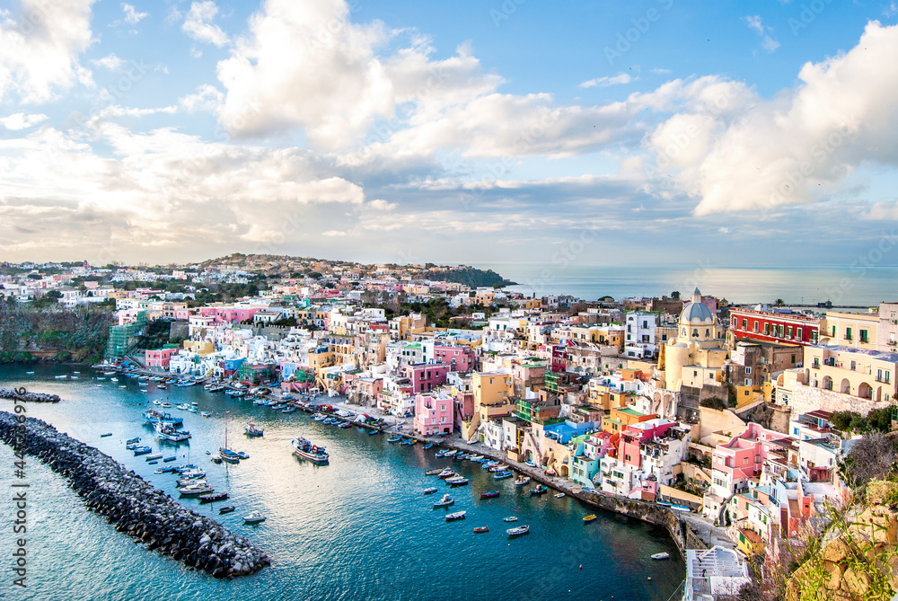 Panoramic view of Marina Corricella, a seaside fishing village in Procida island, with colorful buildings, harbor and boats, in Procida Island, province of Naples, Italy