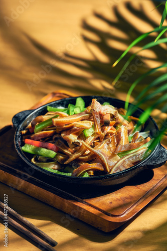 Pickled and fried pork ears in a frying pan. Chinese cuisine.