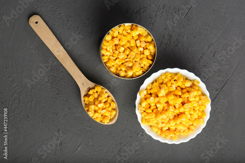 canned corn in a spoon, jar and on the table top view