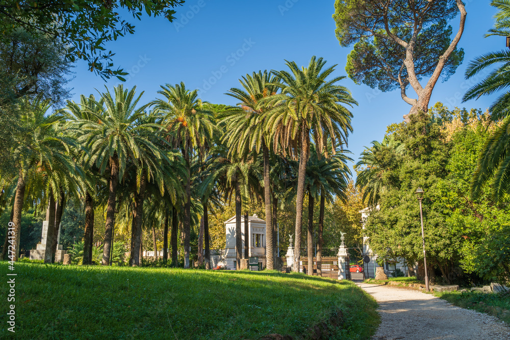 Beautiful European green park in Villa Torlonia in Rome, Italy with pathways, trees and lawns.