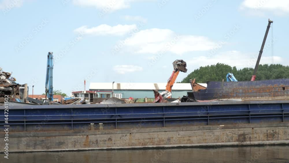 Excavator machine demolishing a rustic old ship Excavator machine demolishing a rustic old ship