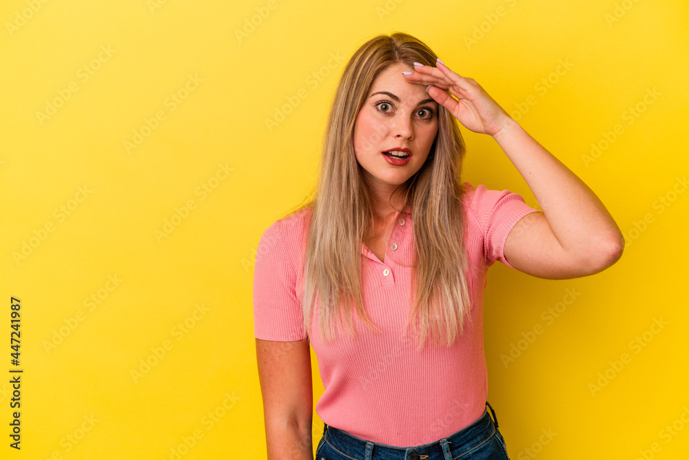 Young russian woman isolated on yellow background shouts loud, keeps eyes opened and hands tense. Young russian woman isolated on yellow background shouts loud, keeps eyes opened and hands tense.