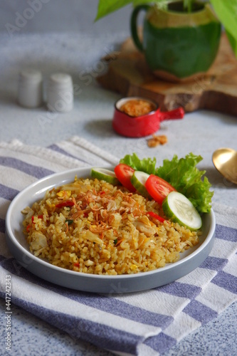 a plate of yellow fried rice with salad on the table 