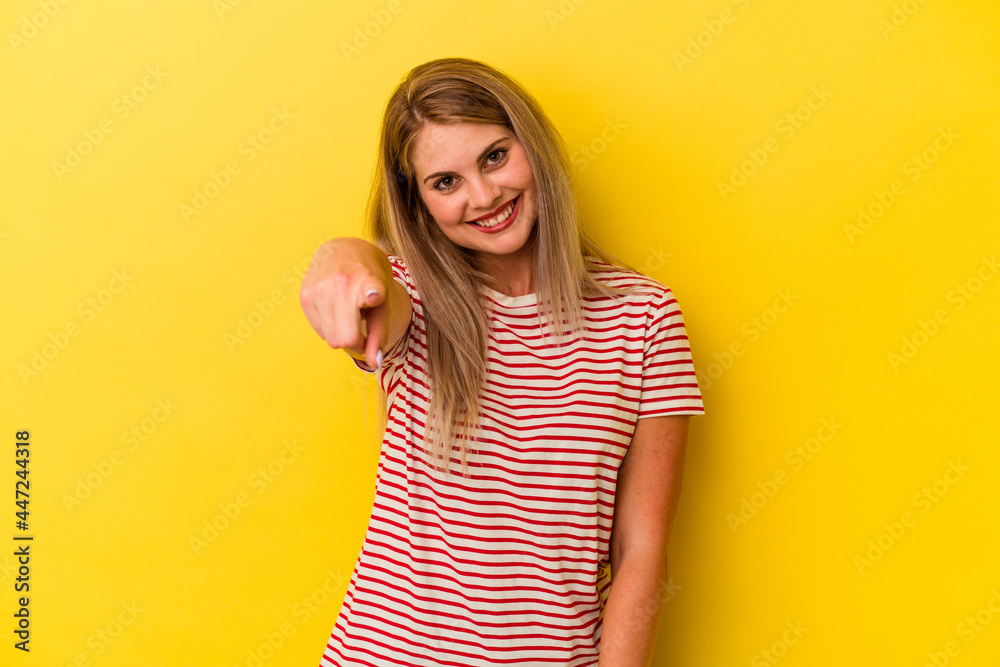 Young russian woman isolated on yellow background cheerful smiles pointing to front. Young russian woman isolated on yellow background cheerful smiles pointing to front.