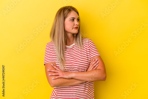 Young russian woman isolated on yellow background dreaming of achieving goals and purposes