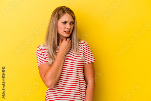 Young russian woman isolated on yellow background suffers pain in throat due a virus or infection.