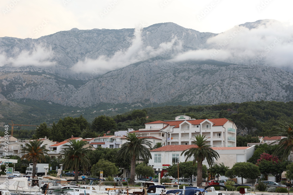 Fototapeta premium view of the town in the mountains. Scenic morning landscape with foggy time lapse in luxury resort