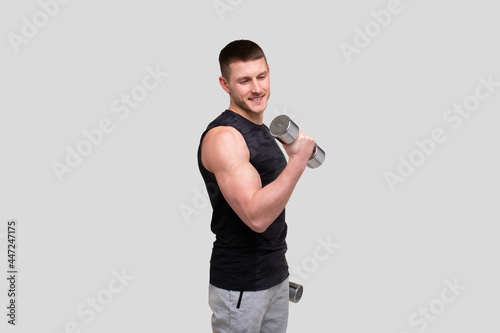 Man Pumping Biceps with Dumbbell. Sprotsman Doing Traning on Biceps Muscles. Gym, Lifting Sport Concept. © Alex