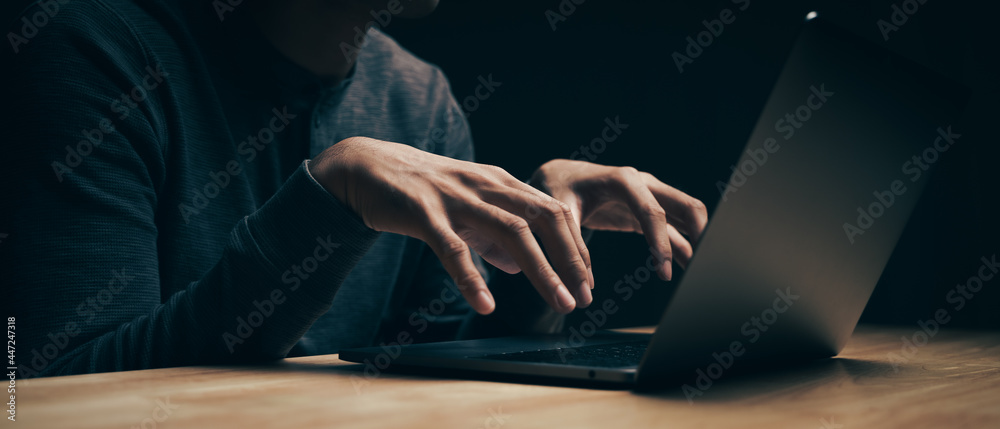 Closeup of hacker is using the laptop computer to coding virus or malware for hacking internet server, Cyber attack, System breaking, Internet crime concept.