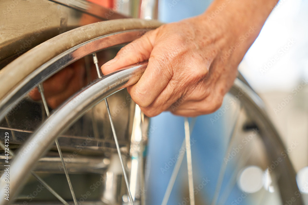 Hand of a patient on the tire of a wheelchair Hand of a patient on the tire of a wheelchair