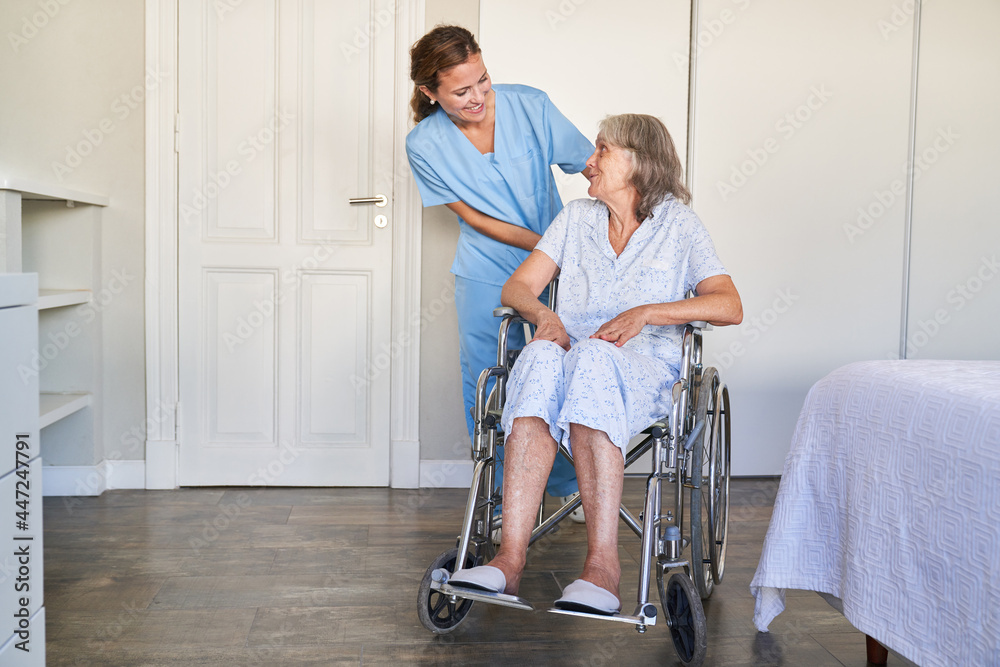 Carer helps elderly woman in a wheelchair after a stroke Carer helps elderly woman in a wheelchair after a stroke