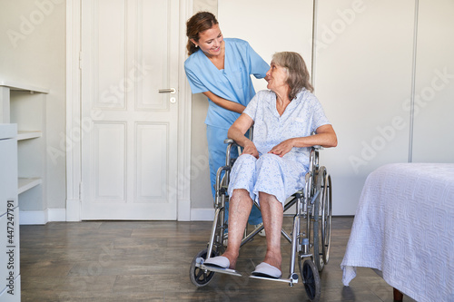 Carer helps elderly woman in a wheelchair after a stroke © Robert Kneschke