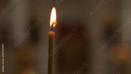 Lonely burning candle close-up in an Orthodox Church. Sacred fire close up.
