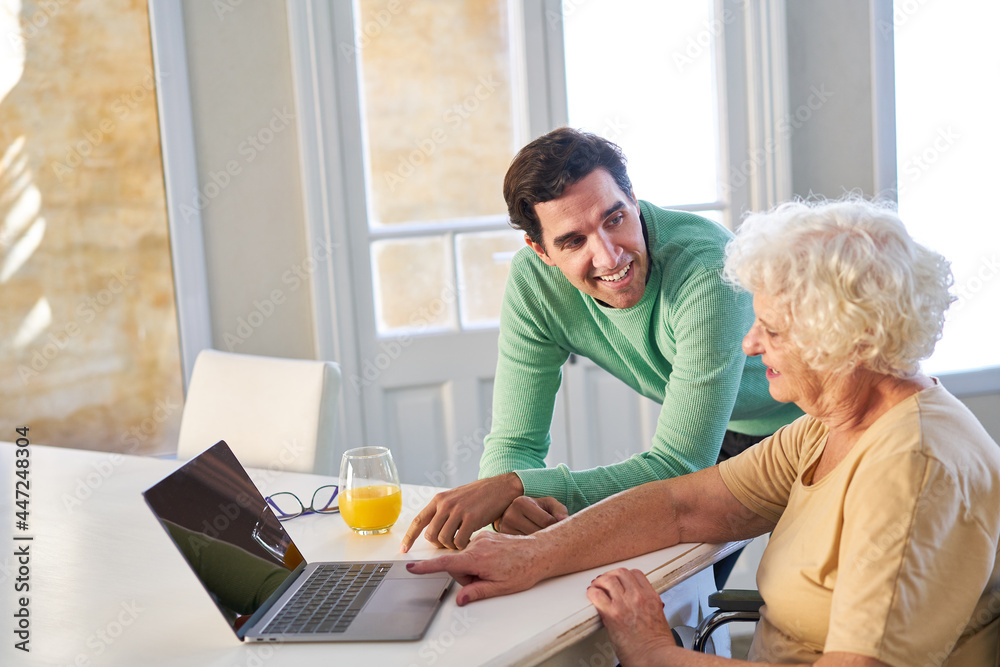 Young man helping senior mother on laptop computer Young man helping senior mother on laptop computer