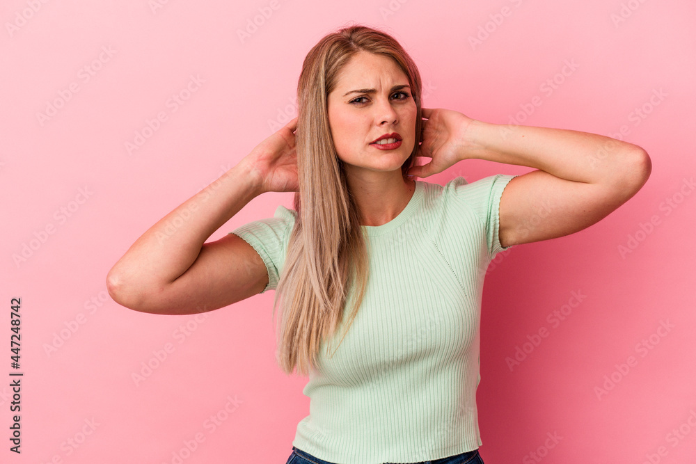 Young russian woman isolated on pink background touching back of head, thinking and making a choice. Young russian woman isolated on pink background touching back of head, thinking and making a choice.