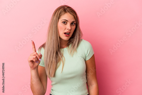 Young russian woman isolated on pink background having an idea, inspiration concept.