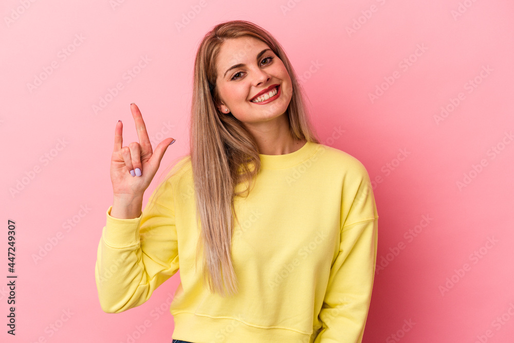 Young russian woman isolated on pink background showing rock gesture with fingers Young russian woman isolated on pink background showing rock gesture with fingers
