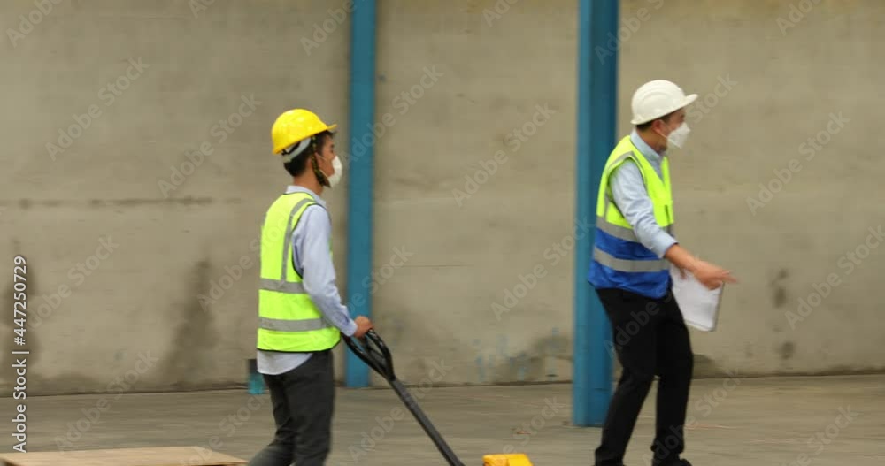 Asian man worker have fun on warehouse lift truck or pallet truck in lage warehouse